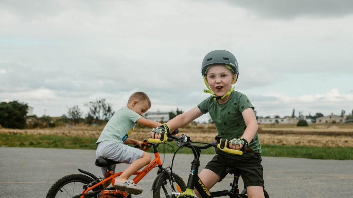 Two children riding bikes in a rural setting, showcasing active play.